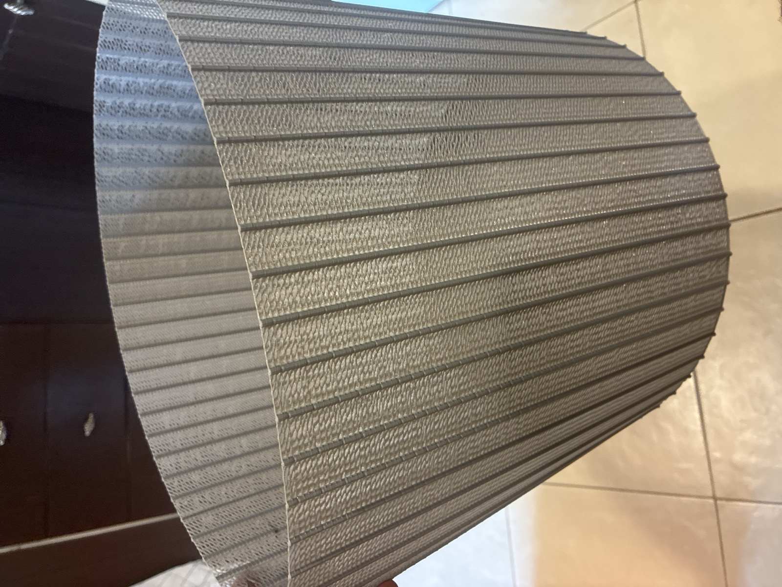 Close view of the printed bucket wall: dark vertical post ribs with a fine woven membrane filling every gap between them, and horizontal ridges where the bridge layers run