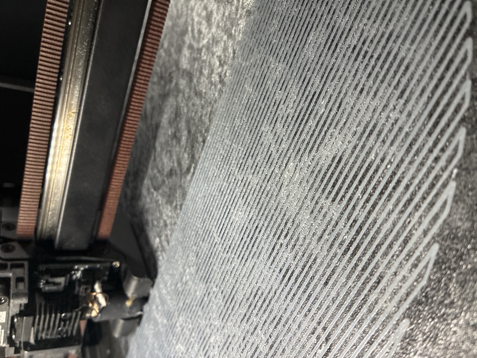 The base after the fix: an even raster of first-layer lines, uniformly spaced and welded down flat across the plate
